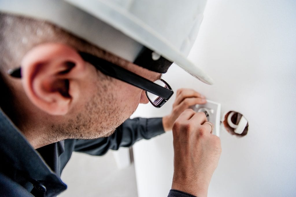 an electrician fitting a new socket into a wall