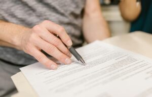 a man holding a pen reading a lease document
